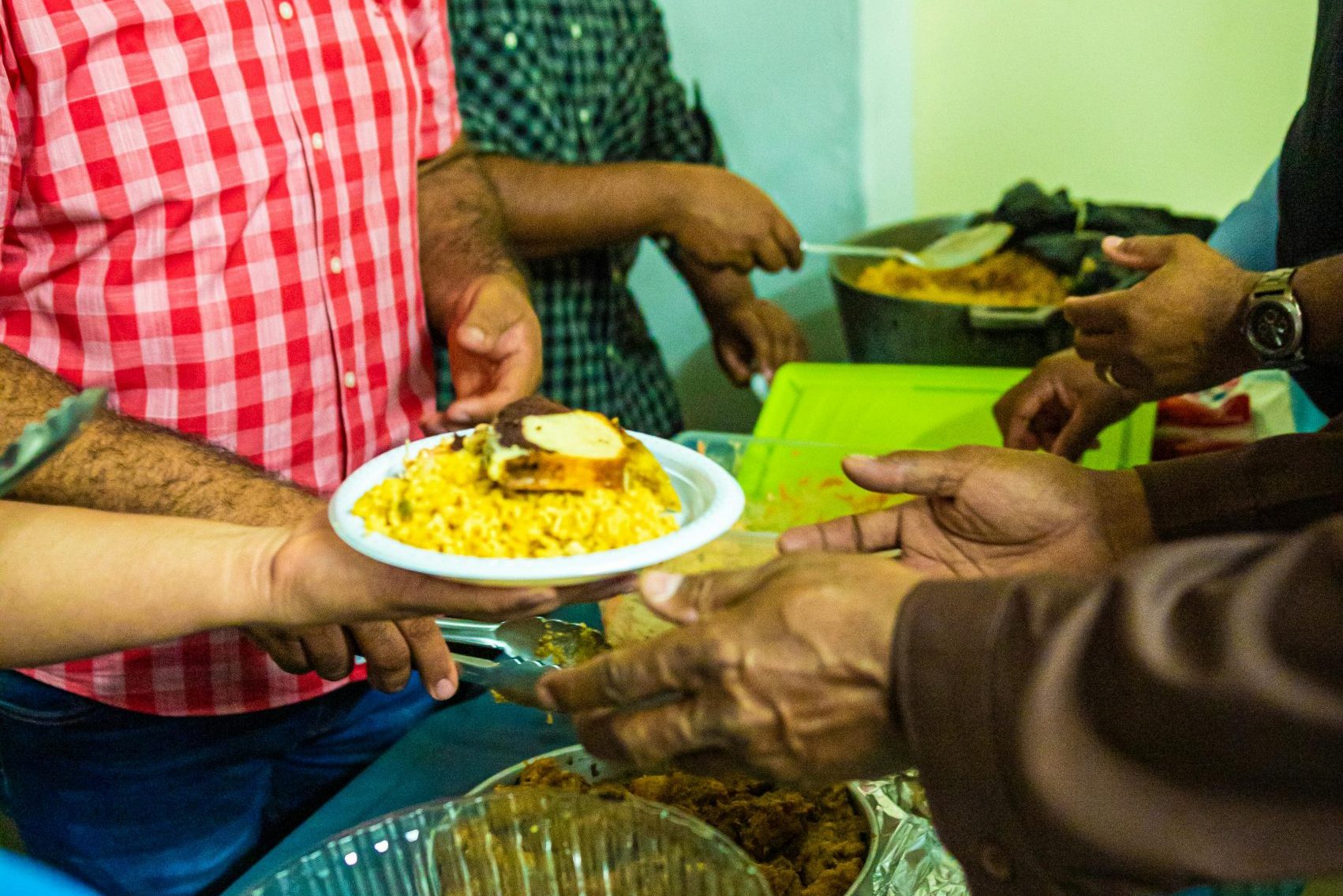 Volunteers serving warm meals at a community event, focusing on togetherness and charity.